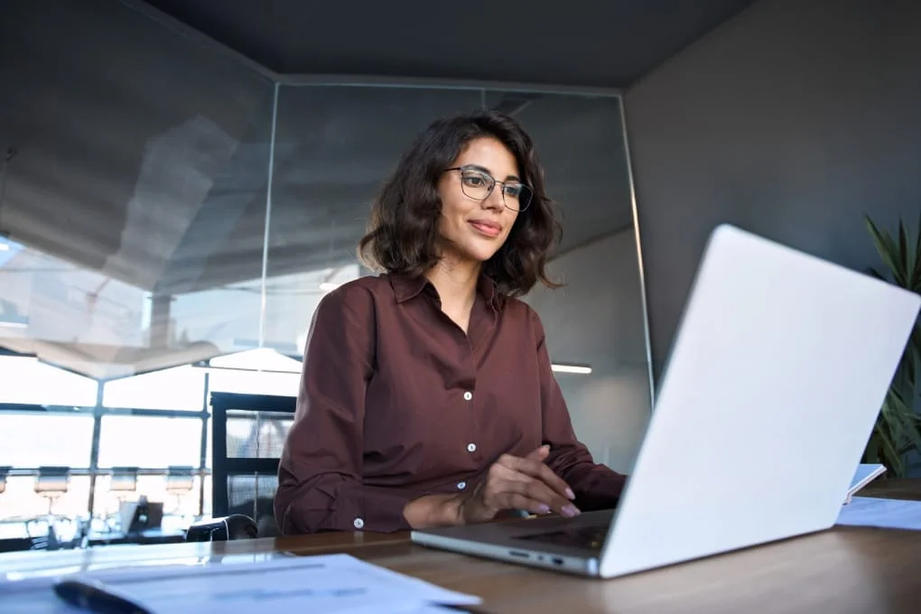 Professional using a laptop in a modern office for business technology planning.