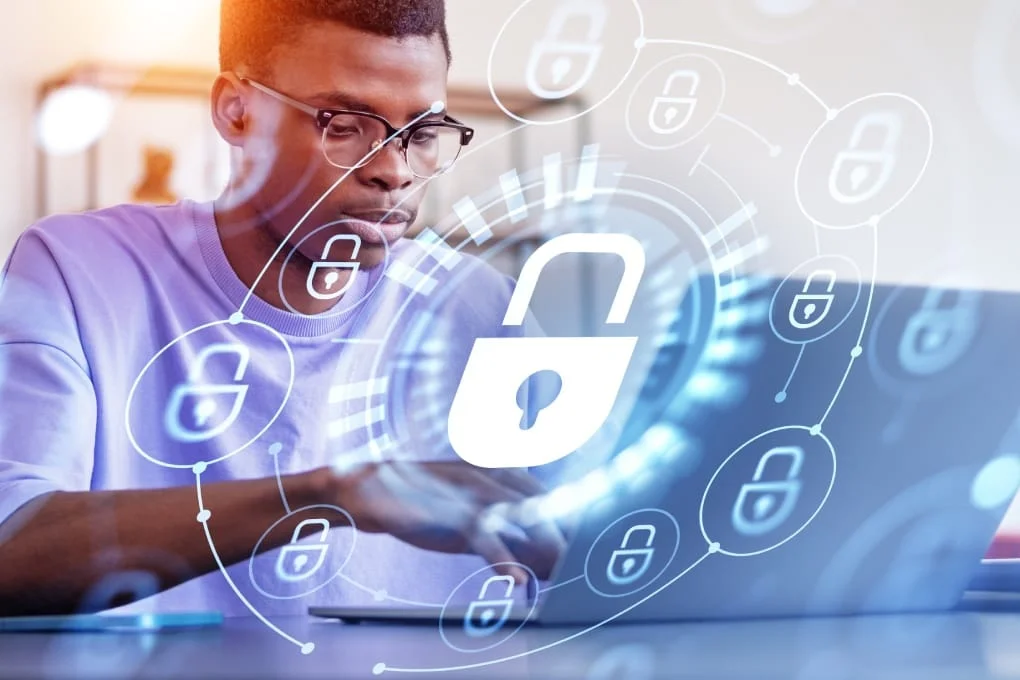 Business user working on a laptop with privacy and data protection symbols.